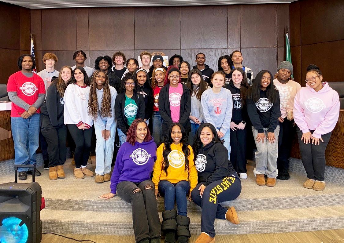 A group of teen volunteers stand together in the Flossmoor Board Room
